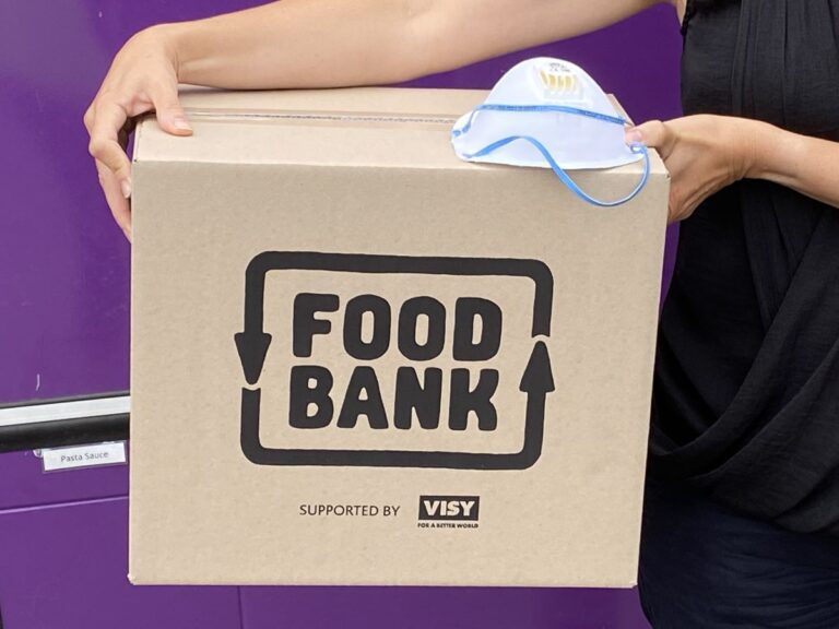 Foodbank Hamper box with Foodbank logo on it and someone holding it on their hip